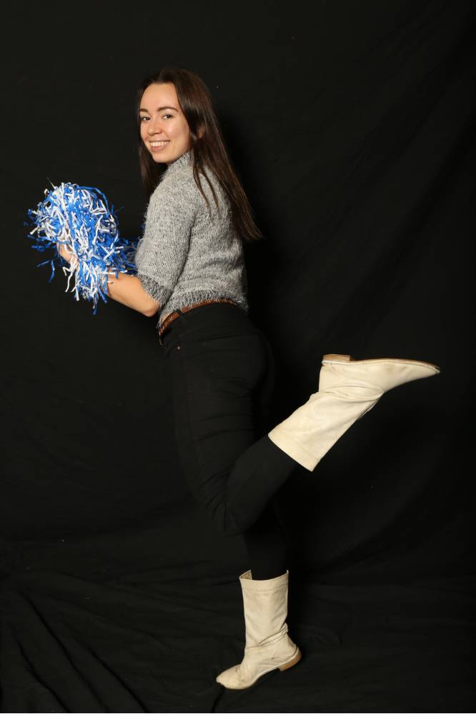 student kicking up leg for photo at photo booth